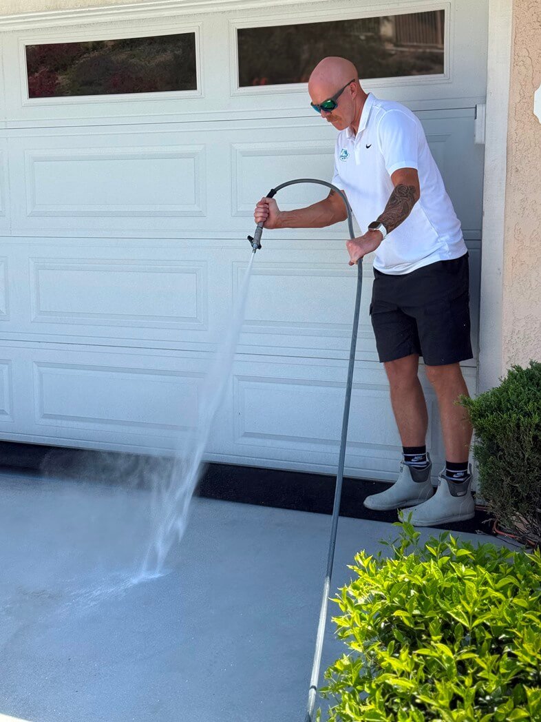 Technician performing Pressure Washing Service on a Fallbrook - CA patio near a stucco home, Technician performing Pressure Washing Service on a driveway in Rancho Bernardo - CA with controlled spray technique, Specialist performing Pressure Washing Service on a walkway in Scripps Ranch - CA near shaded landscaping, Pressure Washing Service in 4S Ranch - CA brightening a concrete driveway beside a landscaped front yard